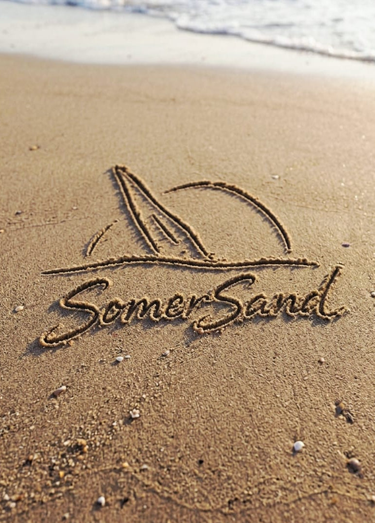 SomerSand logo engraved in sand with ocean waves in the background