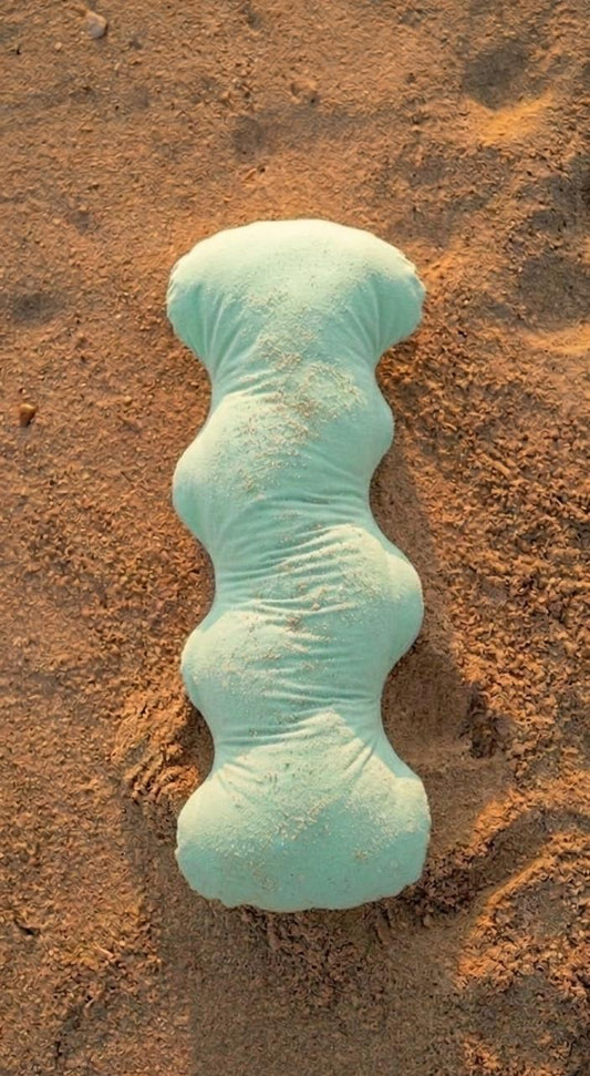 Turquoise Pillow on sandy ground